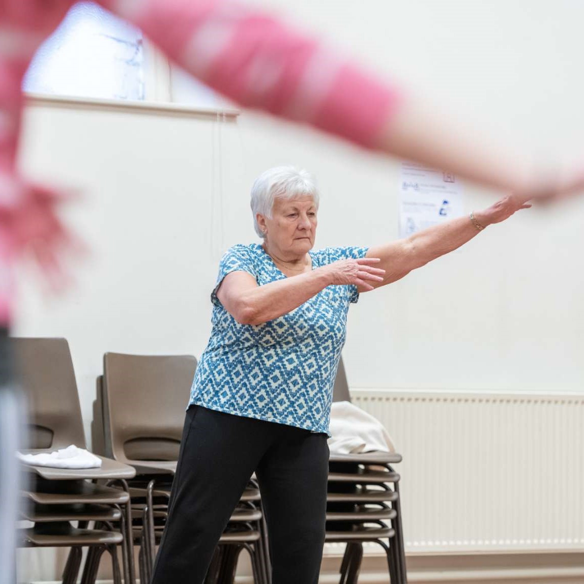 Elderly lady dancing and holding both arms out the side