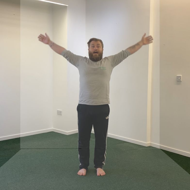 Male dancer stood with arms open in a V shape reaching the sky